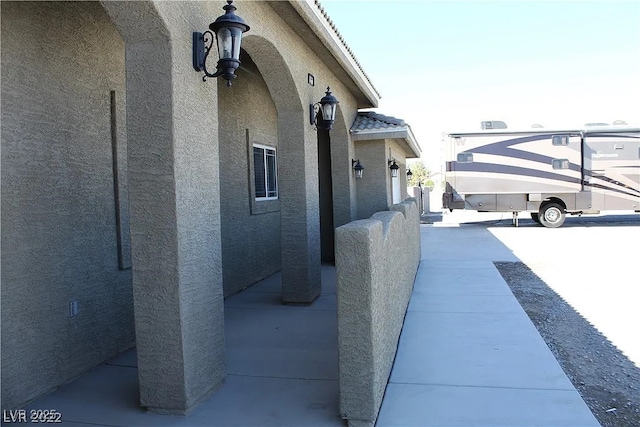 view of side of property featuring stucco siding and a tiled roof
