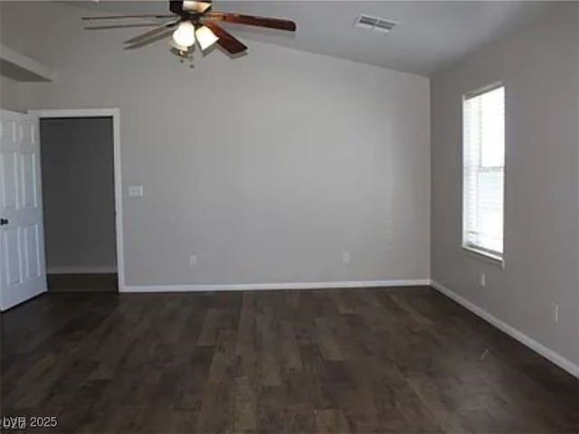 empty room with visible vents, baseboards, a ceiling fan, and dark wood-style floors