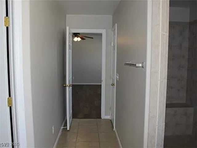 hall with baseboards and tile patterned flooring