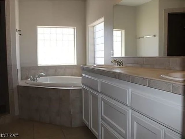 bathroom with a bath, tile patterned floors, plenty of natural light, and vanity