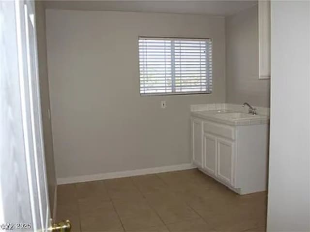 bathroom featuring tile patterned flooring, vanity, and baseboards