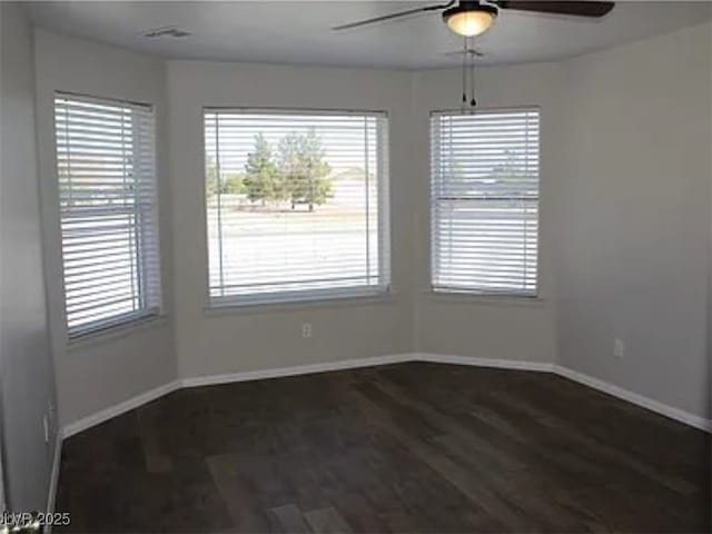 unfurnished dining area with dark wood-style floors, baseboards, and ceiling fan