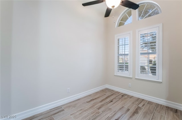 spare room with baseboards, a ceiling fan, and wood tiled floor