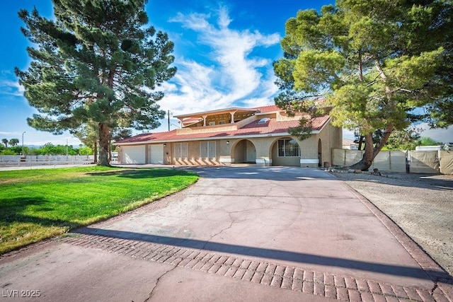 1410 E Serene Ave, Las Vegas, NV 89123 - mediterranean / spanish house with a front yard, stucco siding, aphalt driveway, an attached garage, and fence