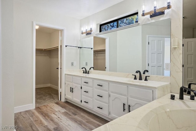 1410 E Serene Ave, Las Vegas, NV 89123 - bathroom with double vanity, wood finished floors, a spacious closet, and a sink