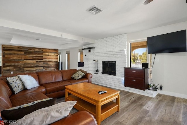 1410 E Serene Ave, Las Vegas, NV 89123 - living area featuring wood finished floors, wood walls, a fireplace, baseboards, and visible vents