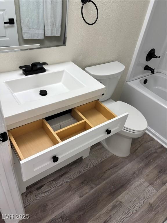 1410 E Serene Ave, Las Vegas, NV 89123 - bathroom with vanity, wood finished floors, shower / bathtub combination, and a textured wall