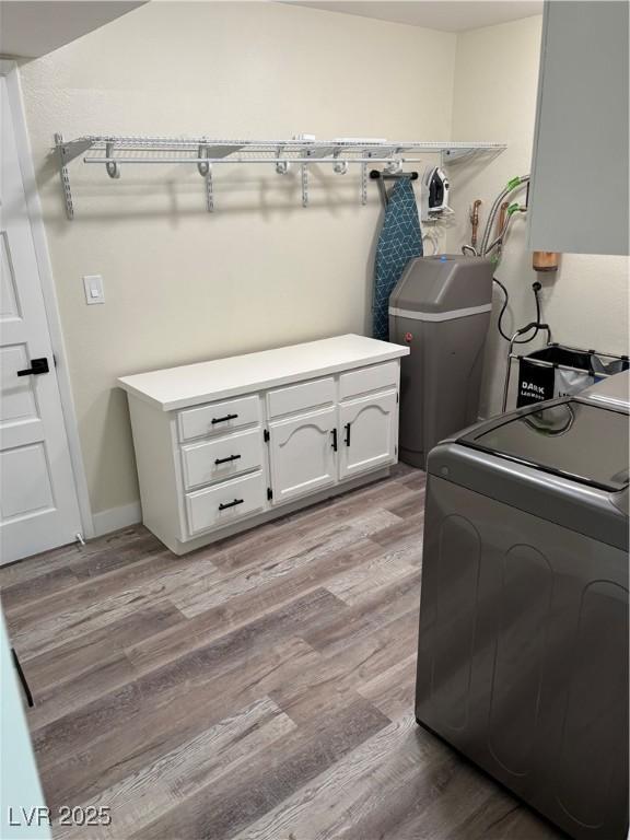 1410 E Serene Ave, Las Vegas, NV 89123 - laundry room with washer / dryer, light wood-style floors, and cabinet space
