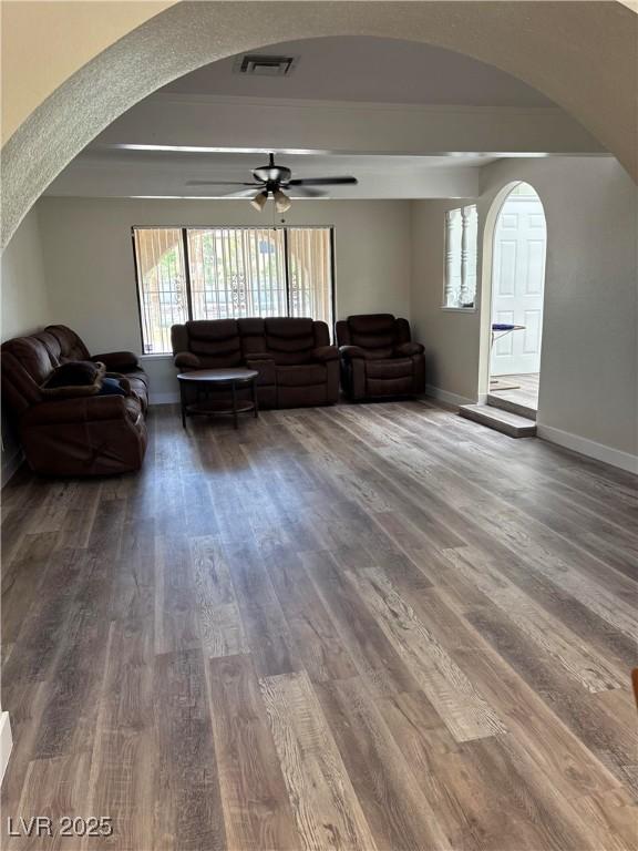1410 E Serene Ave, Las Vegas, NV 89123 - living room featuring arched walkways, ceiling fan, wood finished floors, and a tray ceiling