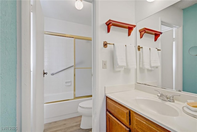 3100 Garehime St, Las Vegas, NV 89108 - full bathroom featuring vanity, toilet, wood finished floors, and bath / shower combo with glass door