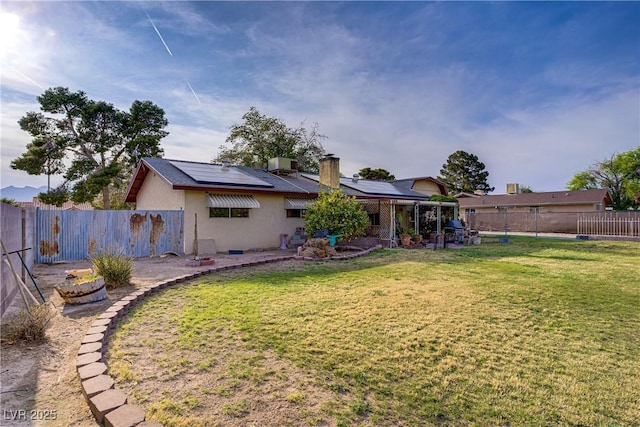 3100 Garehime St, Las Vegas, NV 89108 - rear view of property featuring roof mounted solar panels, a chimney, and stucco siding