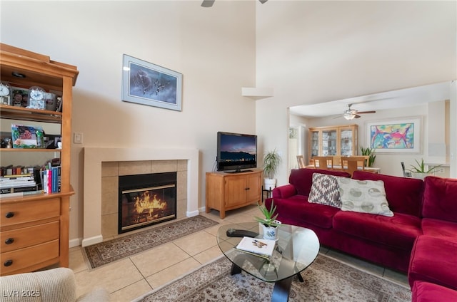 7945 Delbonita Ave, Las Vegas, NV 89147 - living room featuring a high ceiling, light tile patterned floors, a fireplace, and a ceiling fan