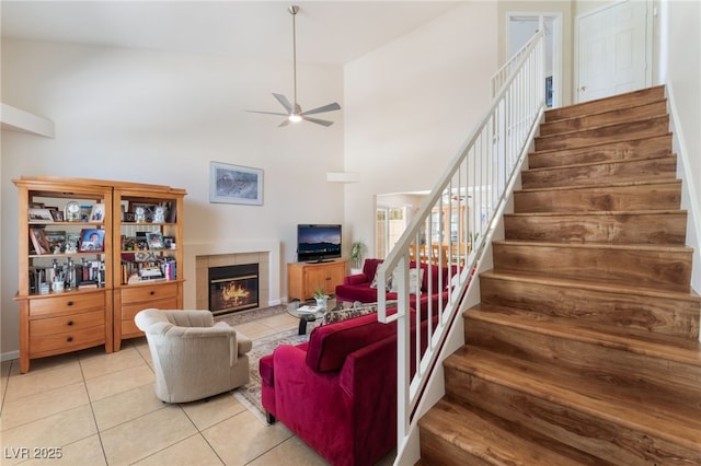 7945 Delbonita Ave, Las Vegas, NV 89147 - living area featuring a tiled fireplace, ceiling fan, tile patterned flooring, and stairs