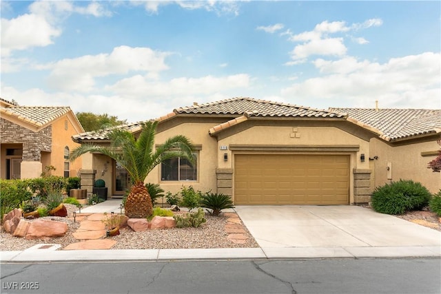 mediterranean / spanish house with stucco siding, a tile roof, concrete driveway, and a garage