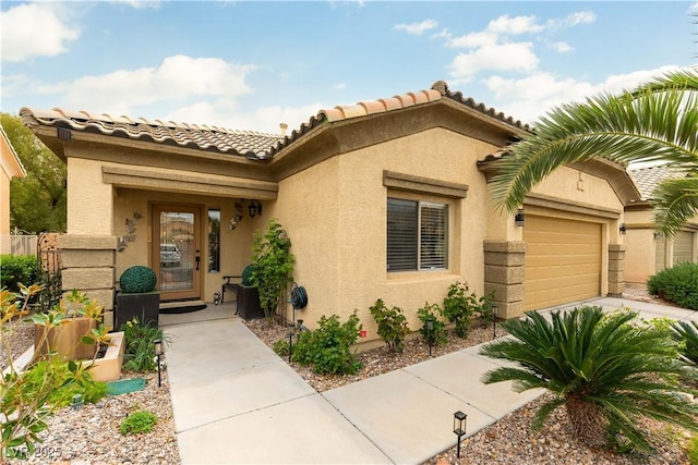 view of front of property with stucco siding, an attached garage, driveway, and a tile roof