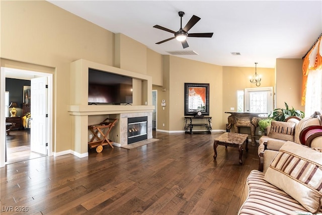 living area with dark wood-style floors, lofted ceiling, visible vents, and a fireplace