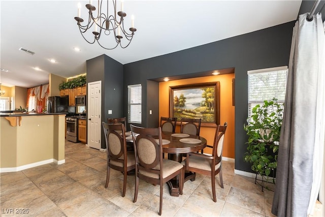 dining space featuring visible vents, baseboards, a healthy amount of sunlight, and an inviting chandelier
