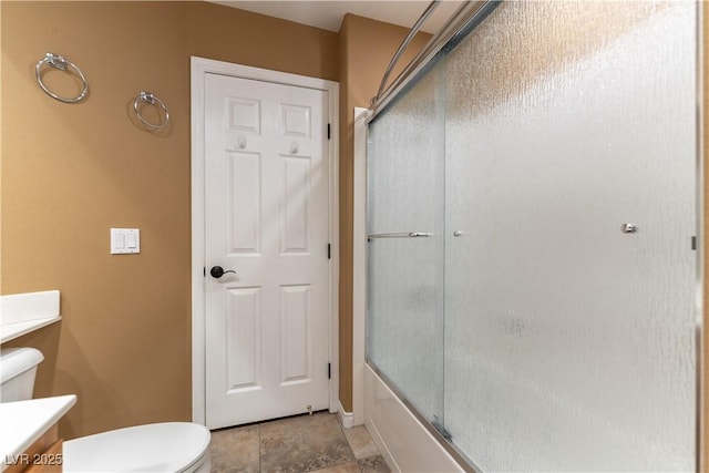 bathroom featuring combined bath / shower with glass door, baseboards, vanity, and toilet