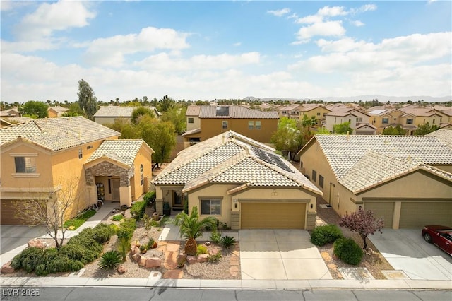 view of front of house featuring concrete driveway, a tiled roof, a residential view, and stucco siding