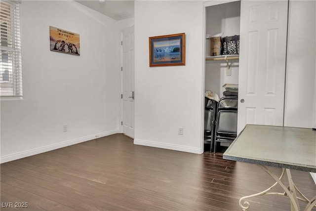 dining space featuring dark wood-style flooring and baseboards