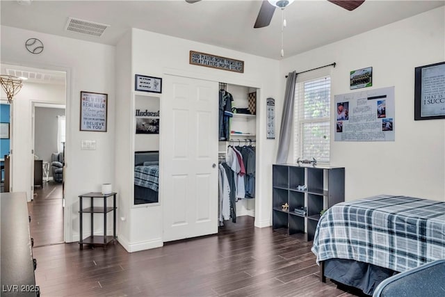 bedroom with visible vents, baseboards, a closet, a ceiling fan, and wood finished floors