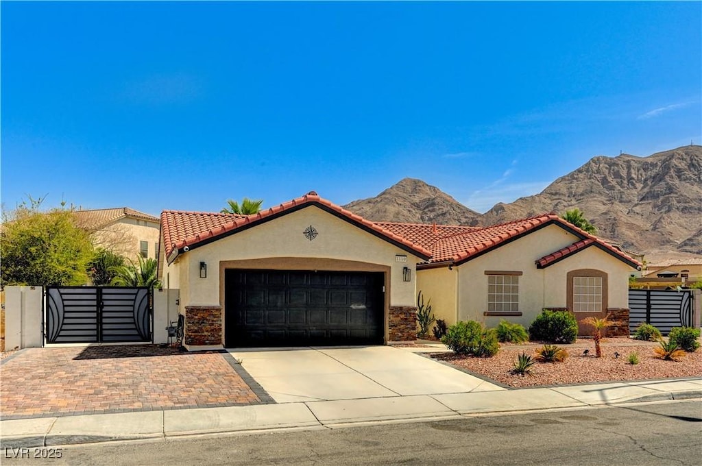 mediterranean / spanish house featuring driveway, stucco siding, a tiled roof, and an attached garage