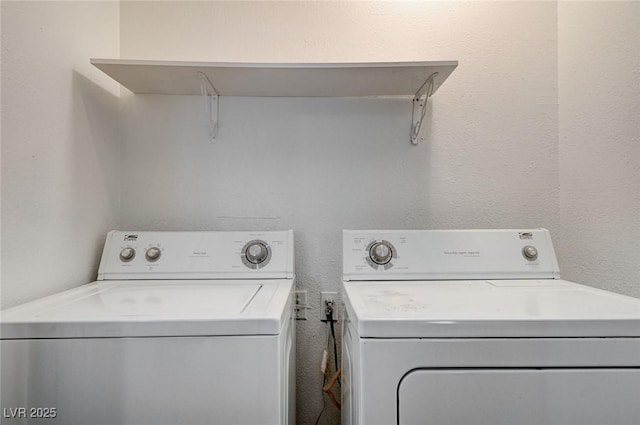 laundry area featuring washing machine and dryer and a textured wall