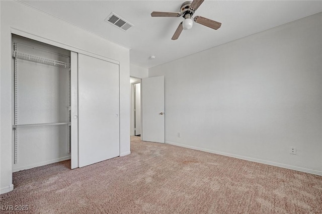 unfurnished bedroom with a closet, baseboards, carpet floors, visible vents, and ceiling fan