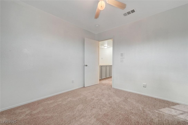 unfurnished room featuring visible vents, light colored carpet, baseboards, and ceiling fan