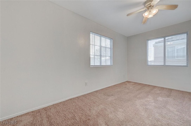 spare room with light carpet, ceiling fan, and baseboards