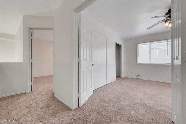 unfurnished bedroom featuring ceiling fan, a closet, baseboards, and carpet floors