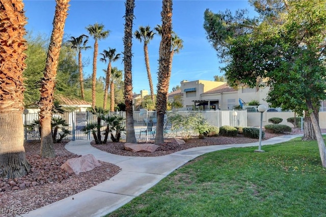 view of property's community featuring a yard and fence