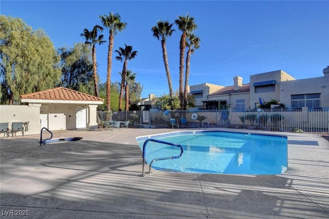 community pool featuring fence and a patio