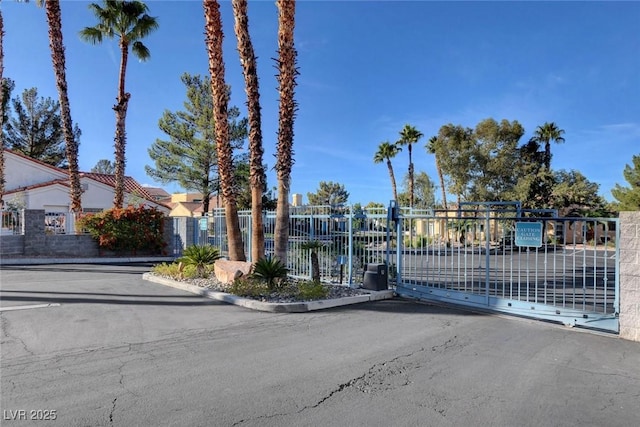 view of road featuring curbs, a gated entry, and a gate