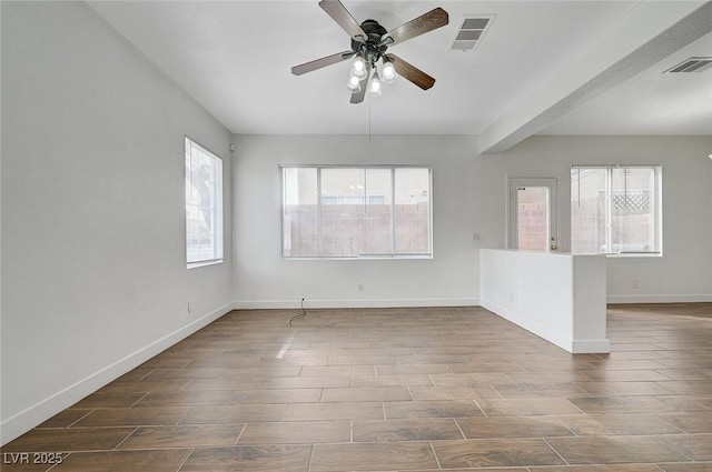 spare room with wood tiled floor, a ceiling fan, and visible vents