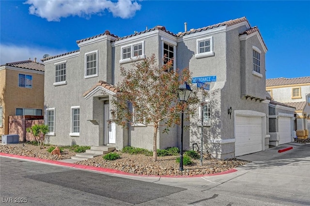 view of front of home featuring stucco siding, a tile roof, an attached garage, concrete driveway, and central AC unit