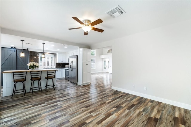2401 Rice Flower Cir, Las Vegas, NV 89134 - kitchen with appliances with stainless steel finishes, a breakfast bar, a barn door, white cabinetry, and a ceiling fan