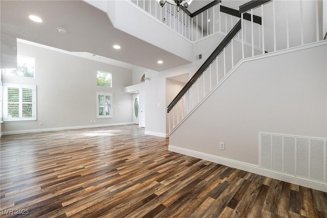 2401 Rice Flower Cir, Las Vegas, NV 89134 - unfurnished living room featuring a towering ceiling, stairs, baseboards, wood finished floors, and recessed lighting