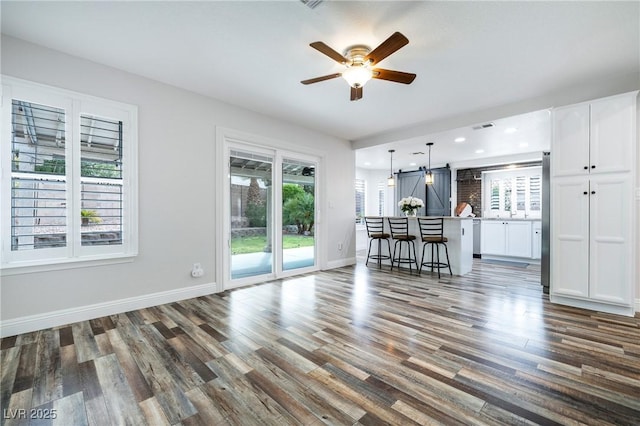 2401 Rice Flower Cir, Las Vegas, NV 89134 - living room with wood finished floors, a barn door, ceiling fan, baseboards, and recessed lighting