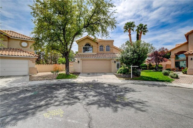 2401 Rice Flower Cir, Las Vegas, NV 89134 - mediterranean / spanish-style house with driveway, stucco siding, a garage, a tile roof, and fence
