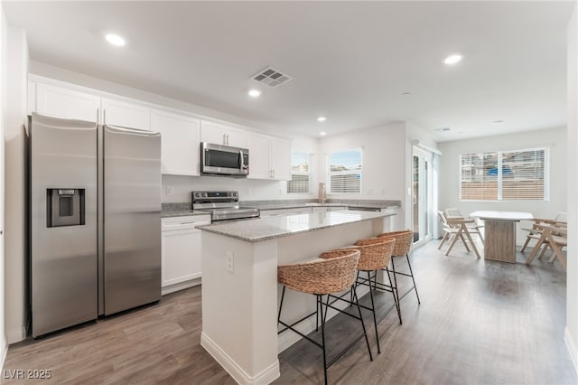 2902 Hemi Orange Ave, North Las Vegas, NV 89086 - kitchen featuring a kitchen island, white cabinets, visible vents, appliances with stainless steel finishes, and a sink