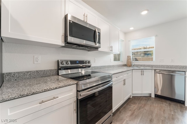 2902 Hemi Orange Ave, North Las Vegas, NV 89086 - kitchen featuring white cabinetry, recessed lighting, appliances with stainless steel finishes, a sink, and light wood finished floors