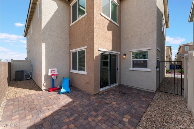 2902 Hemi Orange Ave, North Las Vegas, NV 89086 - rear view of house featuring central AC unit, fence, a patio, stucco siding, and a gate