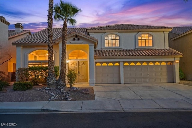 2445 Antler Point Dr, Henderson, NV 89074 - mediterranean / spanish-style home featuring an attached garage, driveway, a tile roof, and stucco siding