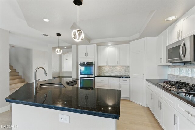 2445 Antler Point Dr, Henderson, NV 89074 - kitchen with appliances with stainless steel finishes, tasteful backsplash, a center island with sink, a raised ceiling, and recessed lighting