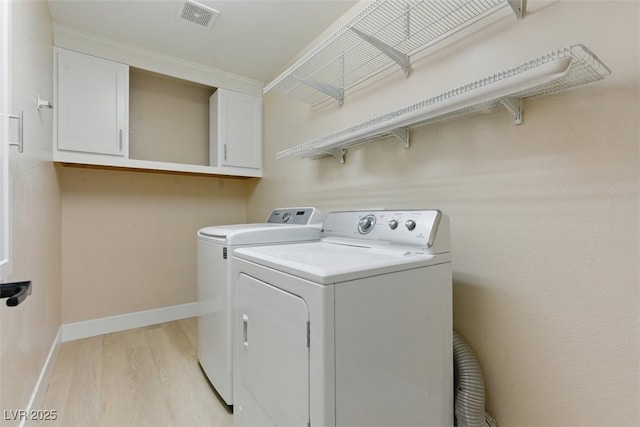 2445 Antler Point Dr, Henderson, NV 89074 - laundry room featuring washing machine and dryer, cabinet space, and light wood finished floors