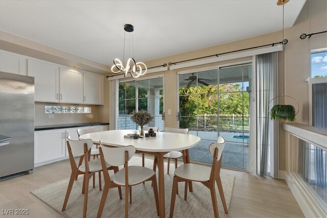 2445 Antler Point Dr, Henderson, NV 89074 - dining area with light wood-style flooring and a chandelier