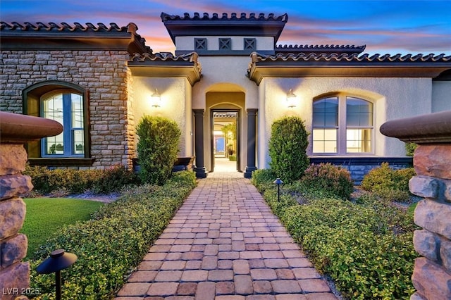 10 Olympia Outlook Dr, Las Vegas, NV 89141 - exterior entry at dusk with stone siding and stucco siding