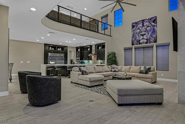 10 Olympia Outlook Dr, Las Vegas, NV 89141 - living area with light wood-type flooring, a towering ceiling, and baseboards