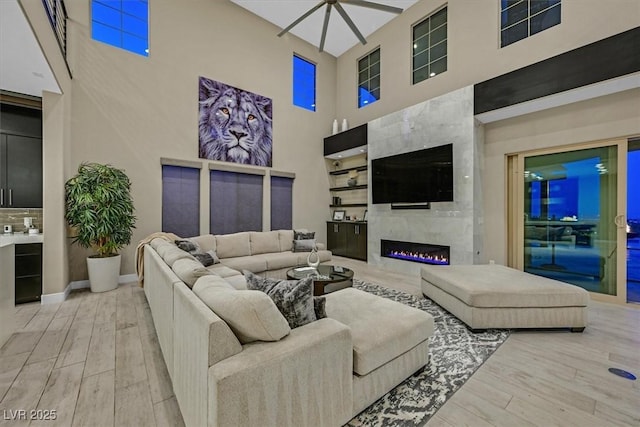 10 Olympia Outlook Dr, Las Vegas, NV 89141 - living area with baseboards, wood finished floors, a premium fireplace, and a towering ceiling